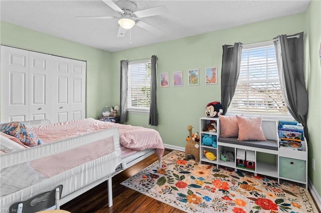 bedroom featuring ceiling fan, a closet, baseboards, and wood finished floors