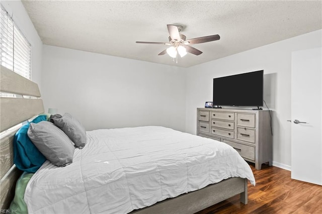 bedroom with a textured ceiling, a ceiling fan, and wood finished floors