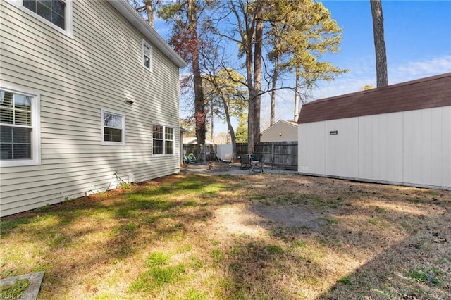 view of yard featuring an outdoor structure, a fenced backyard, and a patio area