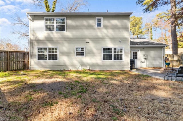 rear view of property with a lawn, a patio, and fence