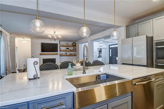 kitchen featuring pendant lighting, a sink, open floor plan, appliances with stainless steel finishes, and crown molding