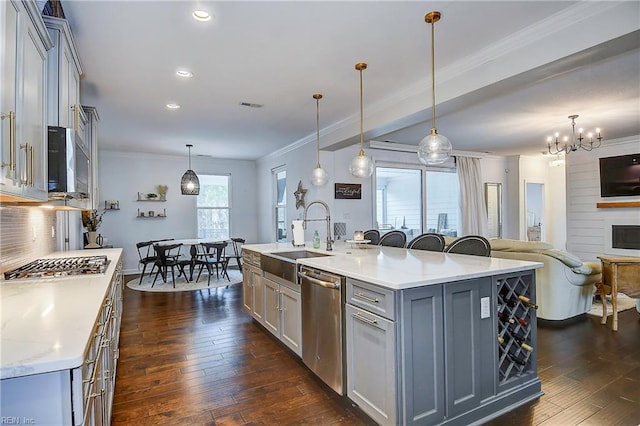 kitchen with ornamental molding, gray cabinets, a sink, dark wood finished floors, and appliances with stainless steel finishes