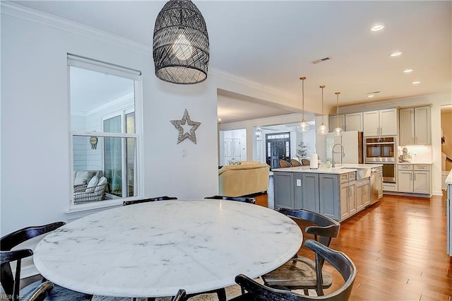 dining room featuring visible vents, recessed lighting, wood finished floors, and ornamental molding