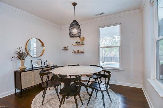 dining area with dark wood finished floors, visible vents, baseboards, and ornamental molding