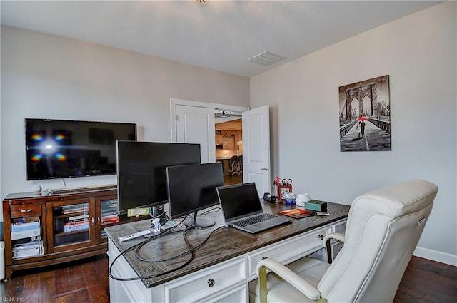 office space with visible vents, baseboards, and dark wood-style flooring