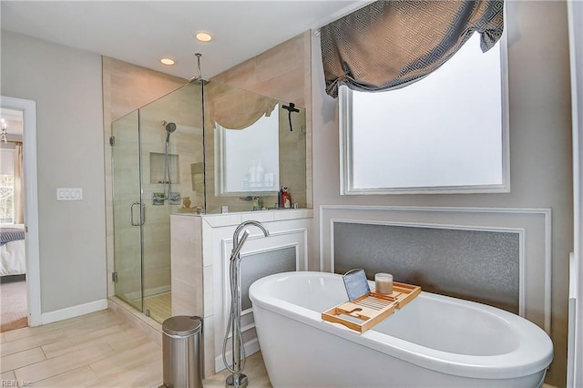 ensuite bathroom featuring baseboards, recessed lighting, a stall shower, ensuite bathroom, and a soaking tub