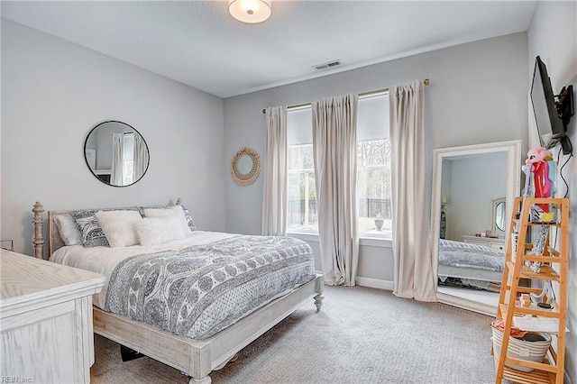 bedroom with light colored carpet, visible vents, and baseboards