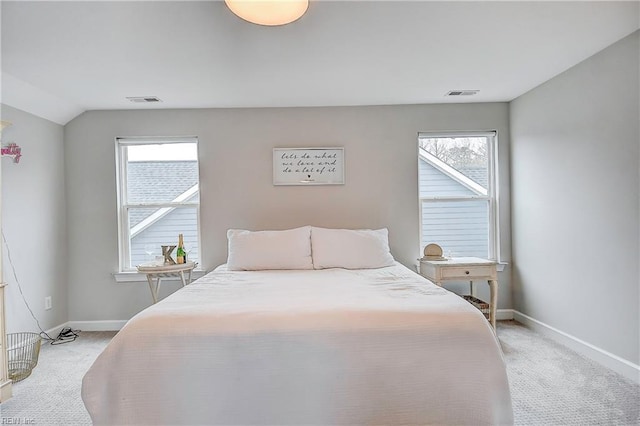 bedroom featuring visible vents, light colored carpet, and baseboards