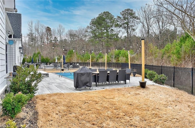 exterior space with grilling area, a fenced in pool, and a fenced backyard