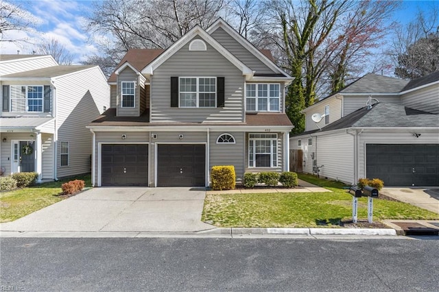 view of front of home featuring an attached garage, concrete driveway, and a front lawn