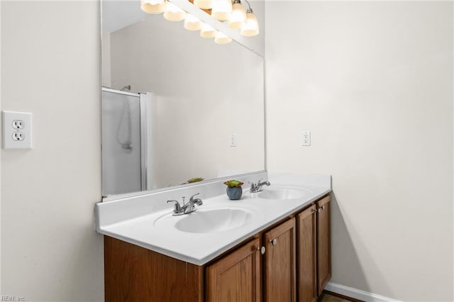 full bathroom featuring double vanity, a shower with door, and a sink