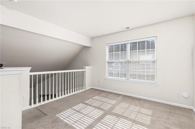 additional living space with visible vents, baseboards, lofted ceiling, and carpet floors