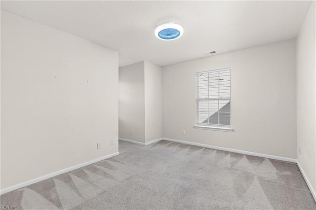 carpeted empty room with visible vents and baseboards