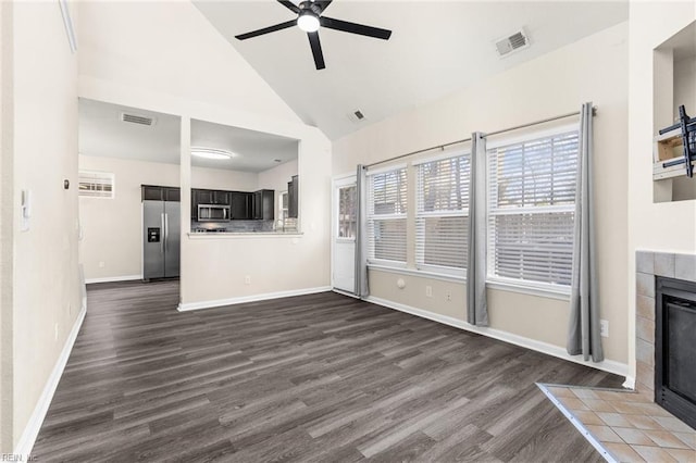 unfurnished living room with visible vents, a tile fireplace, dark wood-type flooring, and a ceiling fan