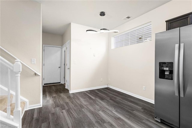 unfurnished dining area with stairway, baseboards, dark wood-type flooring, and visible vents