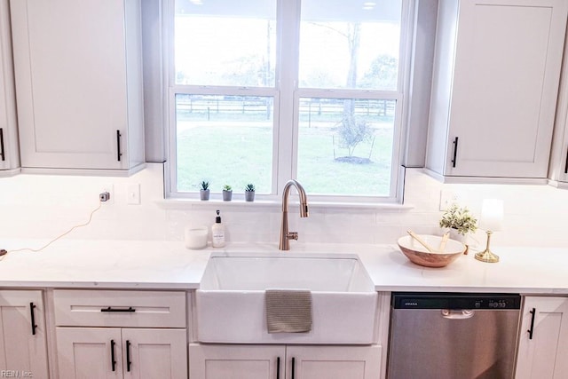 kitchen with a sink, dishwasher, a wealth of natural light, and light countertops