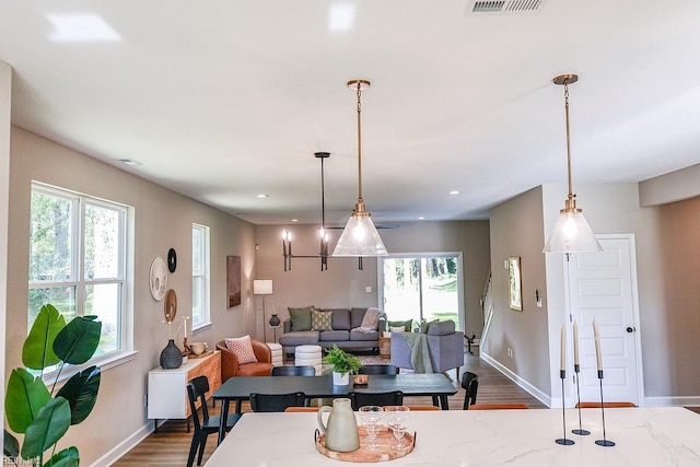 dining room with dark wood-style floors, plenty of natural light, and baseboards