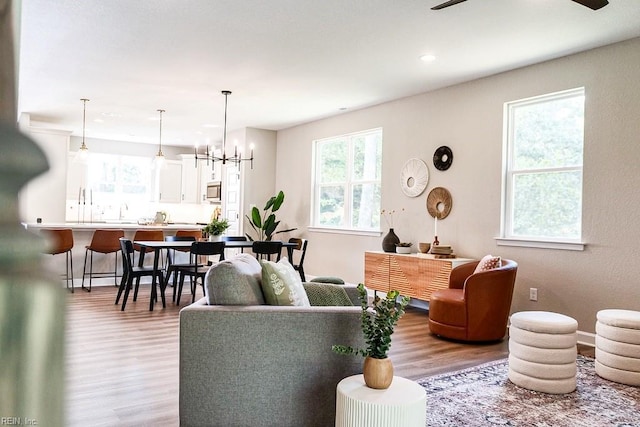 living room featuring light wood finished floors, recessed lighting, and an inviting chandelier