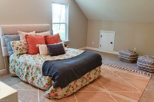 bedroom featuring lofted ceiling, baseboards, and carpet floors