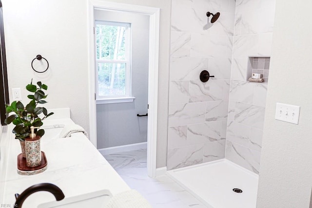 bathroom with marble finish floor, a shower stall, baseboards, and double vanity