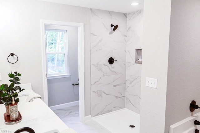 bathroom with baseboards, marble finish floor, and tiled shower