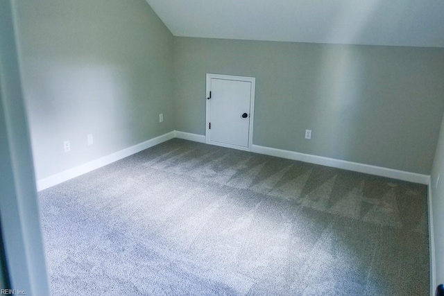 bonus room with baseboards, dark colored carpet, and vaulted ceiling