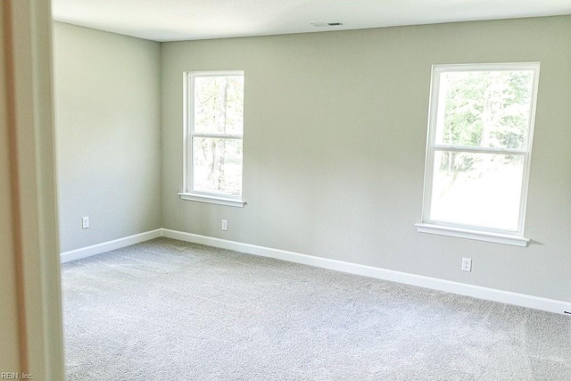 carpeted empty room featuring visible vents and baseboards