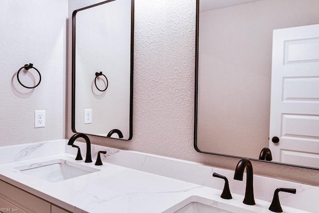 bathroom with vanity and a textured wall