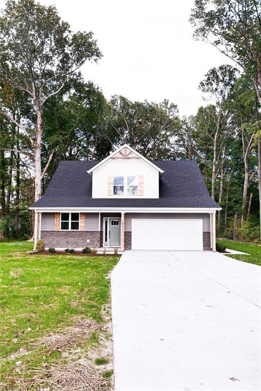 traditional-style home with a front yard, a garage, and driveway