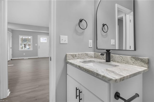 bathroom with vanity, wood finished floors, and baseboards