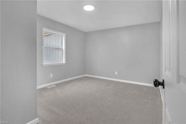 carpeted spare room with visible vents and baseboards