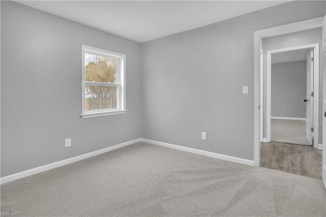 carpeted empty room featuring baseboards