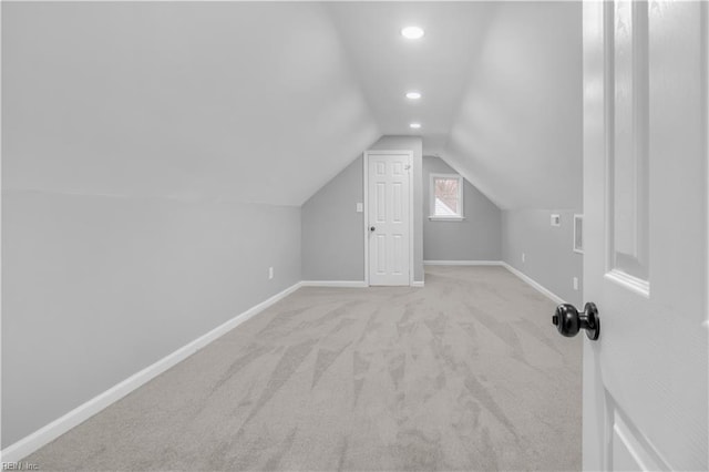 additional living space featuring baseboards, lofted ceiling, and carpet flooring