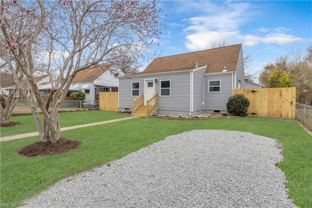 back of house with entry steps, fence, a yard, a shingled roof, and crawl space