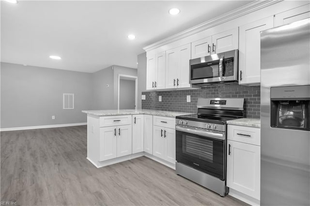 kitchen with tasteful backsplash, white cabinetry, stainless steel appliances, a peninsula, and light wood finished floors