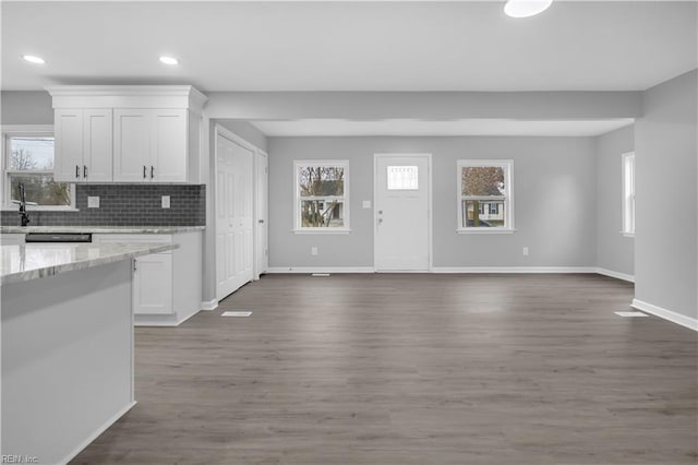 kitchen featuring backsplash, dark wood-style floors, white cabinets, and baseboards