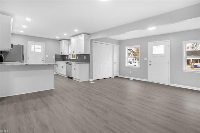 kitchen featuring stainless steel dishwasher, refrigerator, a healthy amount of sunlight, and tasteful backsplash