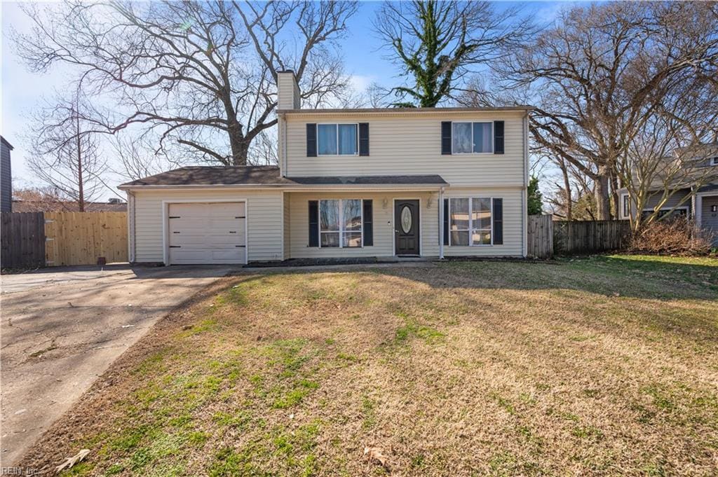 traditional home featuring a front lawn, a chimney, an attached garage, and fence