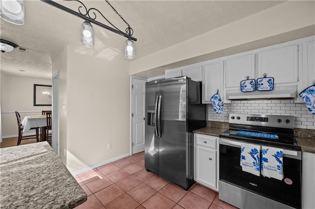 kitchen featuring light tile patterned floors, extractor fan, white cabinets, appliances with stainless steel finishes, and tasteful backsplash