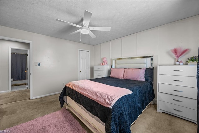 bedroom with baseboards, light colored carpet, a ceiling fan, and a textured ceiling