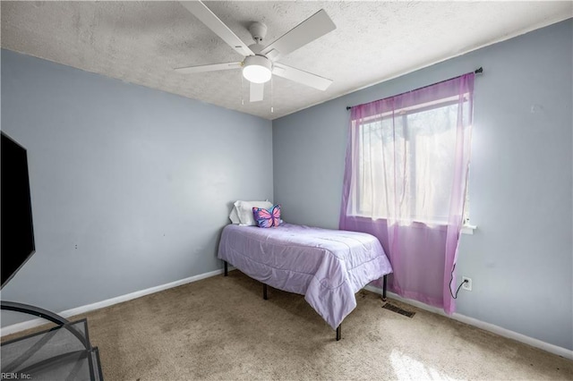 bedroom featuring baseboards, visible vents, carpet floors, and a textured ceiling