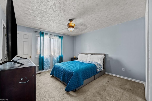 bedroom with a ceiling fan, carpet, baseboards, and a textured ceiling