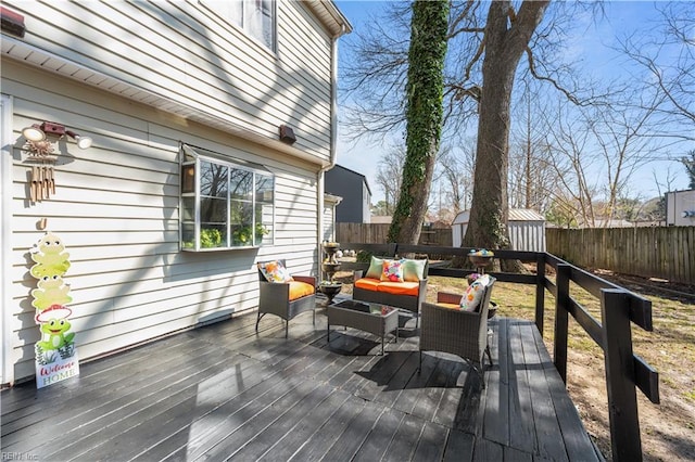 wooden terrace featuring an outdoor living space and a fenced backyard