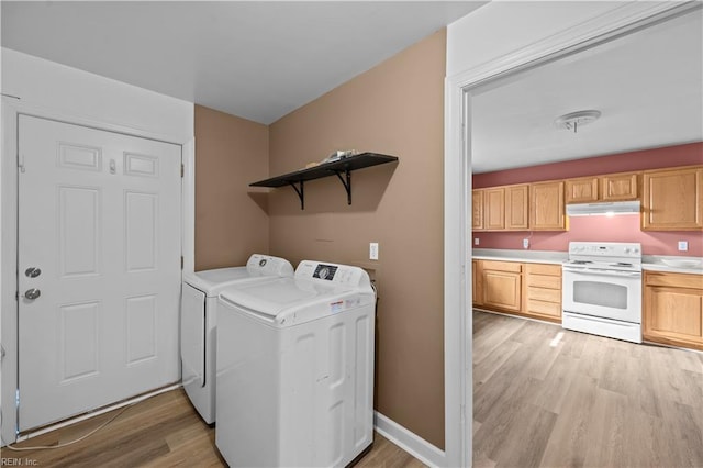 washroom featuring washer and clothes dryer, laundry area, light wood-type flooring, and baseboards