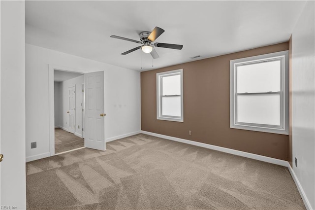 unfurnished room featuring carpet flooring, visible vents, a ceiling fan, and baseboards