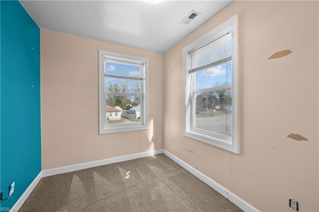 spare room with visible vents, carpet flooring, and baseboards