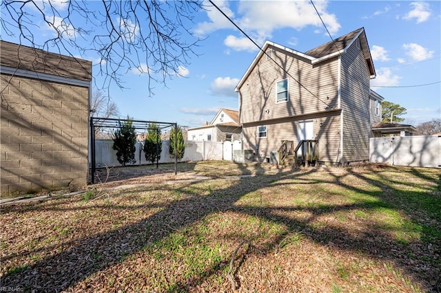 back of house with a yard, a fenced backyard, and entry steps