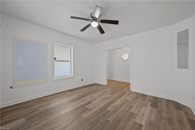 unfurnished room featuring baseboards, wood finished floors, and a ceiling fan