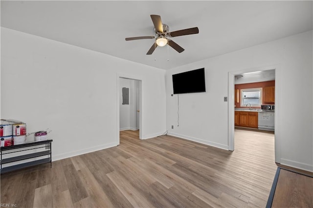 living area featuring light wood-style flooring, electric panel, baseboards, and ceiling fan