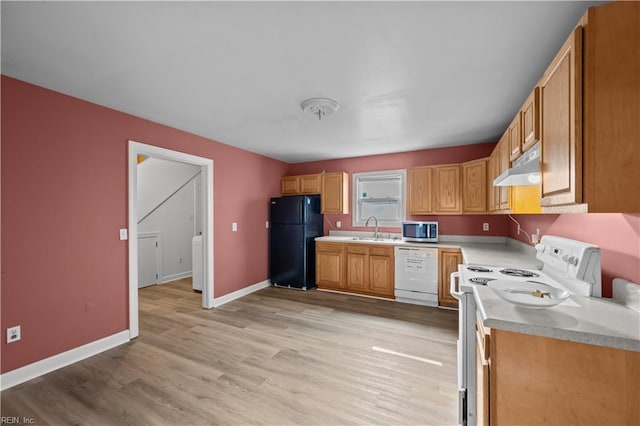 kitchen with baseboards, under cabinet range hood, light countertops, light wood-style flooring, and white appliances